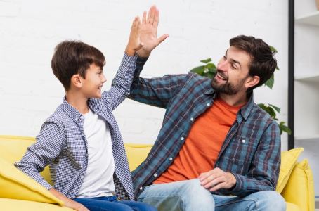 A boy giving high five to man