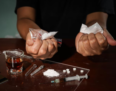 A person holding substance in hands with alcohol near by