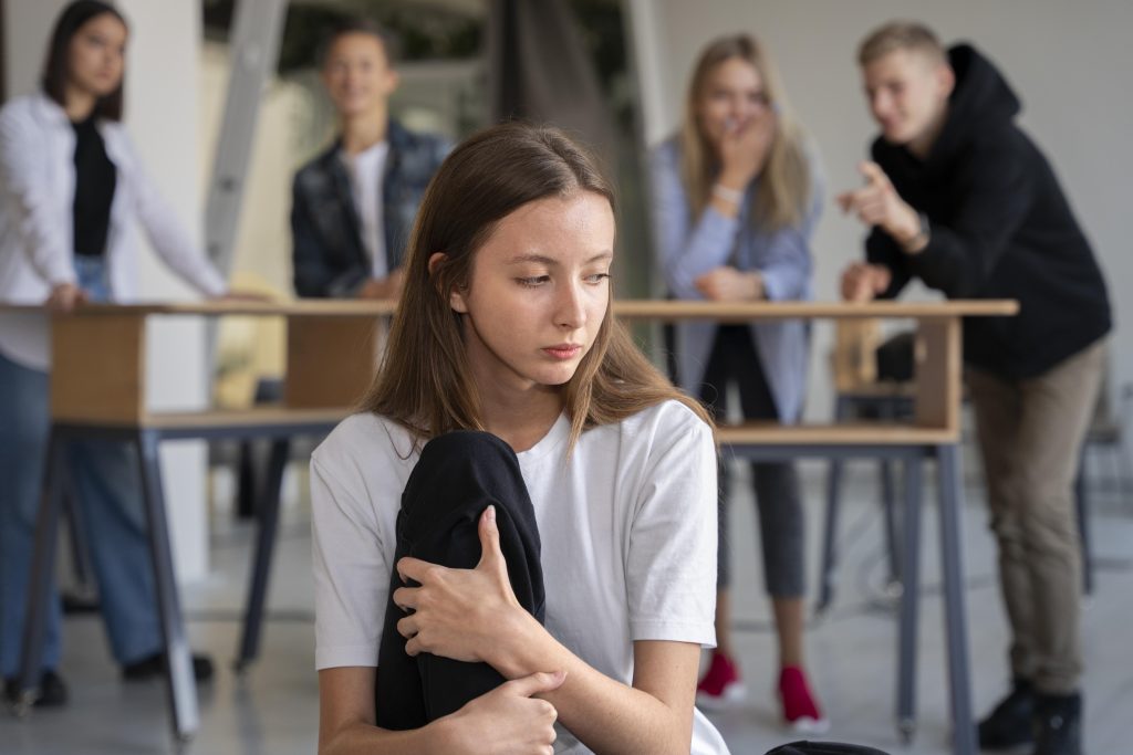 Person experiencing bullying and social isolation in a school or workplace setting